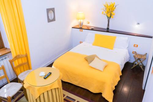um quarto com uma cama com um cobertor amarelo em La Torretta em Tuscania