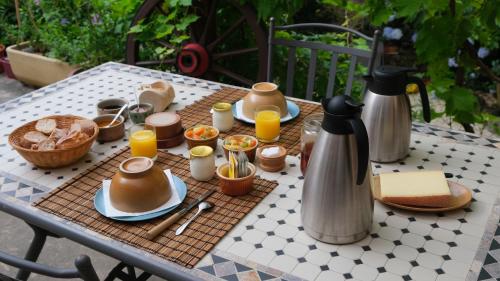 ein Tisch mit Essen und Getränken darauf in der Unterkunft le Corral chambre d'hôte in Cheminas