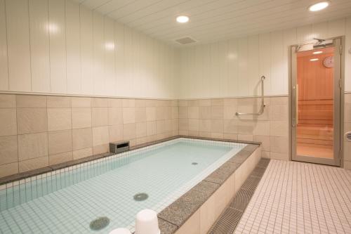 a swimming pool in a bathroom with a shower at Kuretake Inn Nagoya Hisayaodori in Nagoya