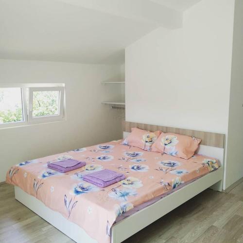 a bedroom with a bed with pink sheets and pink pillows at The Brothers Villa Hotel in Ohrid