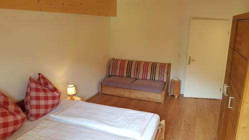 a small room with a bed and a couch at Haus Garten An der Sonne in Niedernsill