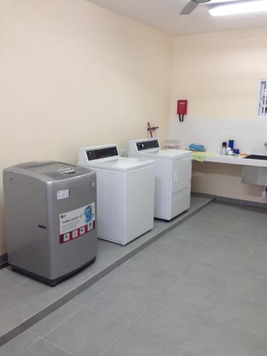 a room with three washing machines in a room at Surfers Beach Self Catering Chalets in Takamaka