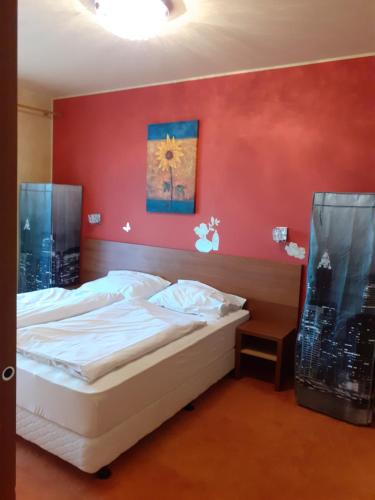 een slaapkamer met een bed met een rode muur bij Apartmán Pod Tatrami in Veľká Lomnica