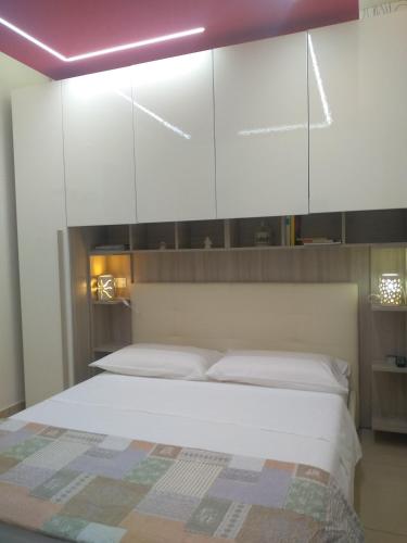 a bedroom with a large bed with white cabinets at B&B Vistamareblu in San Foca