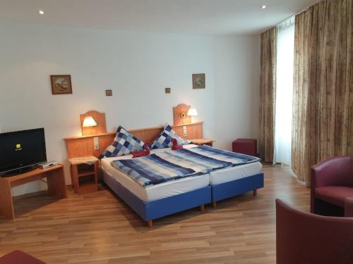a hotel room with a bed and a television at Zirbe - Bayerischer Hof in Rüdesheim am Rhein