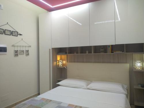 a bedroom with a bed with a large white cabinet at B&B Vistamareblu in San Foca