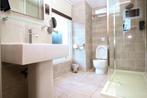 uma casa de banho com um lavatório e um WC em City Apartments em Glasgow