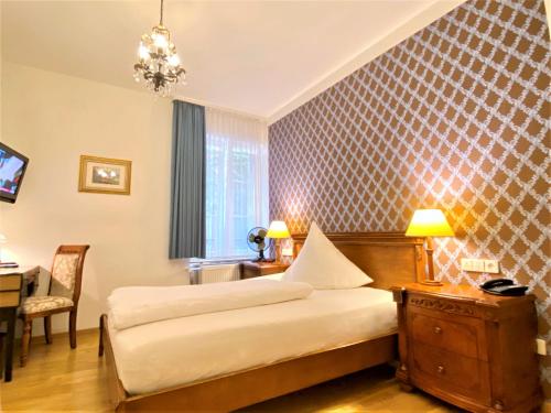 a hotel room with two beds and a table and a desk at Hotel Rathausglöckel in Baden-Baden
