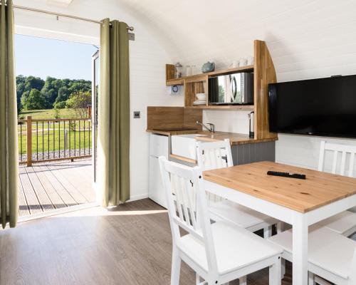 a kitchen and dining room with a table and a television at Weedingshall Lodges in Falkirk