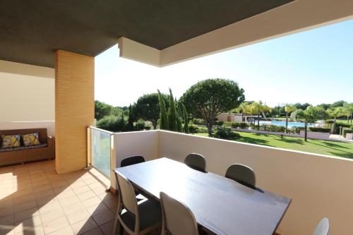 a dining room with a table and chairs on a balcony at Monte Laguna - Clever Details in Vilamoura