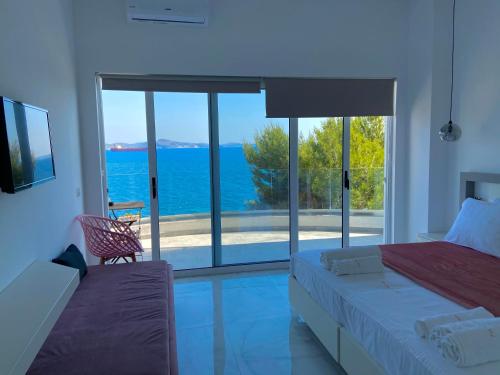 a bedroom with a bed and a view of the ocean at Sea Horizon Vsl Suites & Apartments in Sarandë