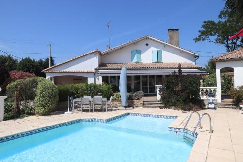 a house with a swimming pool in front of a house at "Les Peyres" in Lamothe-Landerron