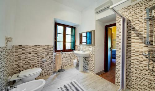 a bathroom with two toilets and a sink and a shower at Casale Romano Resort e Relais in Motta Camastra
