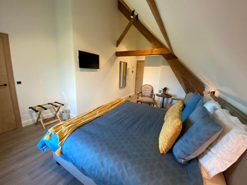 a bedroom with a blue bed in a attic at Madelette B&B in Moorslede
