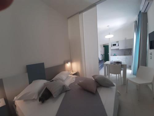 una camera con letto e cuscini e una cucina di GIOANTHONY monolocale a Porto Cesareo