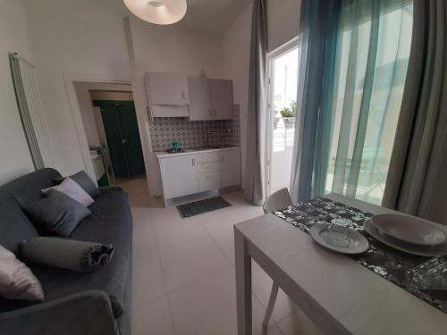 un soggiorno con un divano e un tavolo di GIOANTHONY monolocale a Porto Cesareo