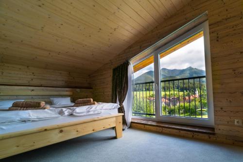 a bedroom with a bed and a large window at Apartments Pemikas I in Liptovský Mikuláš