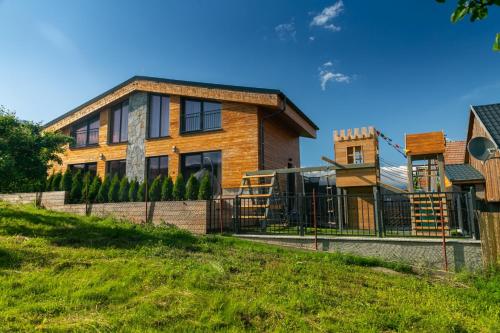 a house on a hill with a fence at Apartments Pemikas I in Liptovský Mikuláš