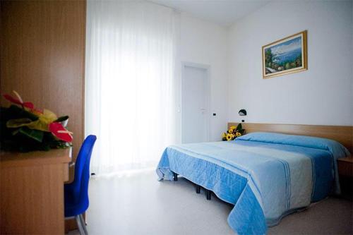 a bedroom with a blue bed and a large window at HOTEL GIAMAICA in Cattolica