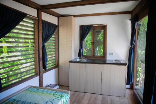 - une cuisine avec un évier et 2 fenêtres dans l'établissement Campeggio Tranquilla, à Baveno