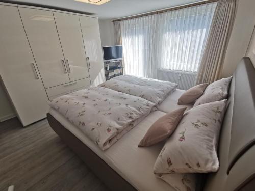 ランゲスハイムにあるFeWo Hageの白いベッド(枕付)が備わるベッドルームです。