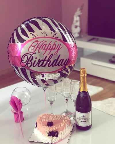 a balloon and a cake and a bottle of champagne at Apartman Japanski vrt, Centar in Vrnjačka Banja
