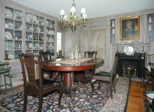 a dining room with a table and chairs and a fireplace at 29 India House in Nantucket