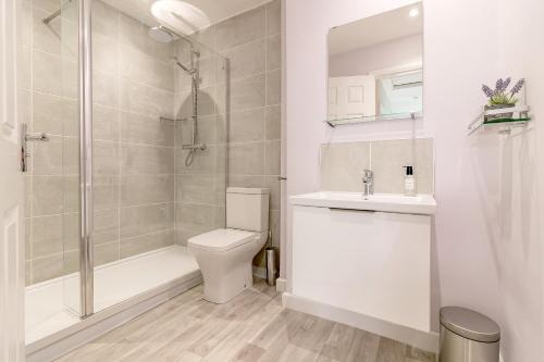 een badkamer met een douche, een toilet en een wastafel bij Meadow House in Cambridge