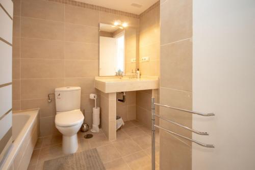 a bathroom with a toilet and a sink and a mirror at La Cala de Mijas Getaway in Sitio de Calahonda