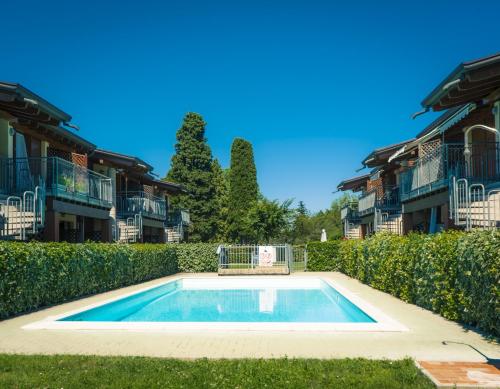 a swimming pool in the yard of a house at Carmel Self-Apartment in Castelnuovo del Garda