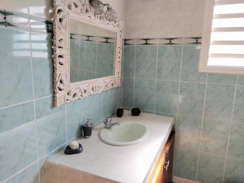 a bathroom with a sink and a mirror and a tub at Spacieux appart T3 à st gilles les bains 80 m2, grande varangue, plage in Saint-Gilles-les-Bains