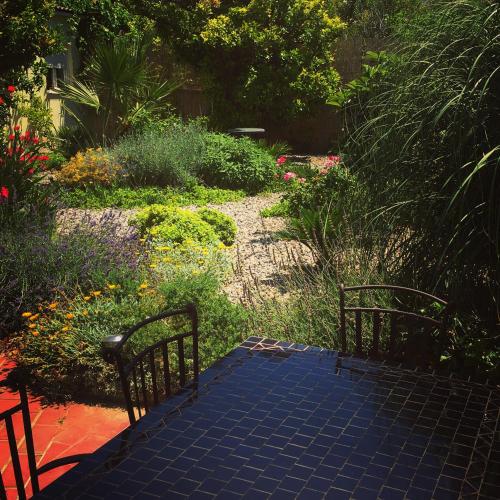 a garden with a table and chairs and flowers at Guesthouse Villa Vice in Split