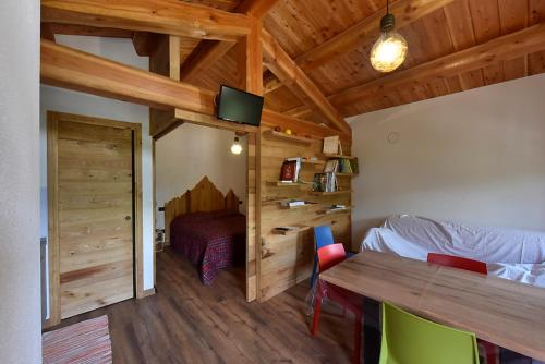 - une chambre avec un lit et un plafond en bois dans l'établissement ALTESTANZEOSTANA, à Ostana