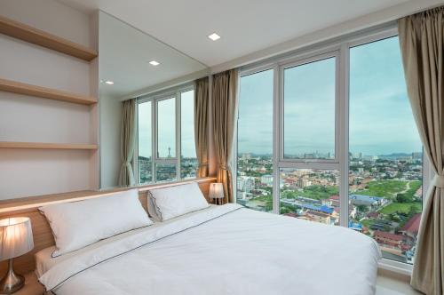 
a hotel room with a large window overlooking the ocean at Sea View - 270 Degree Panorama Views High Floor Balcony - Central - Free WIFI - Full Kitchen in Pattaya South
