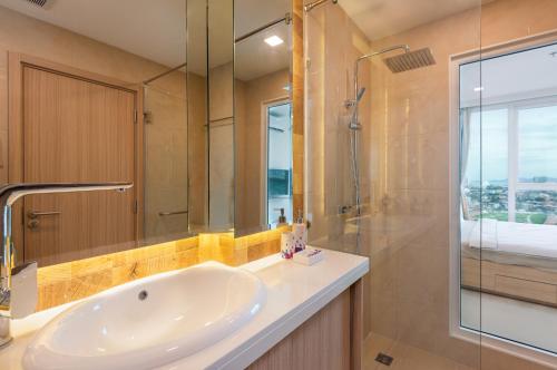 a bathroom with a sink and a glass shower at Rare Panoramic Sea, City & Mountain Views - XXL Balcony - Free Fast WIFI - Pool - City Garden Tower 2317 in Pattaya South