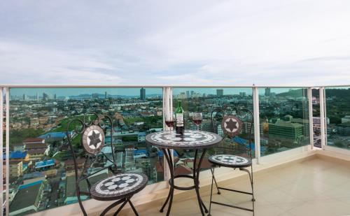 
a dining room table with a balcony overlooking a city at Sea View - 270 Degree Panorama Views High Floor Balcony - Central - Free WIFI - Full Kitchen in Pattaya South
