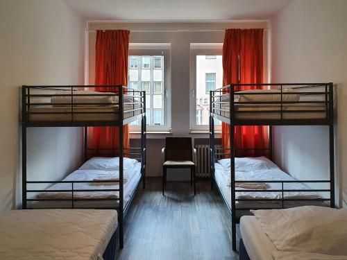 a room with three bunk beds and a window at Aparthouse Graf-Adolf in Düsseldorf