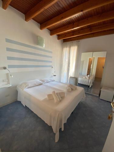 1 dormitorio con 1 cama blanca grande y toallas. en CARUGIO ROOMS Vernazza, en Vernazza