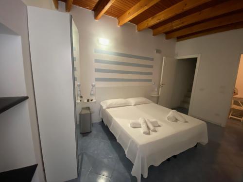 Un dormitorio con una cama blanca con toallas. en CARUGIO ROOMS Vernazza, en Vernazza