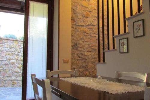 comedor con mesa, sillas y pared de piedra en Il Picchio Verde, en Ravigliano