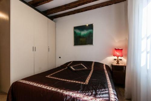 ein Schlafzimmer mit einem Bett und einer roten Lampe in der Unterkunft Casa a San Marco in Venedig