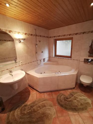 a bathroom with a tub and a sink and a toilet at Ferienpark Leitzingen in Soltau