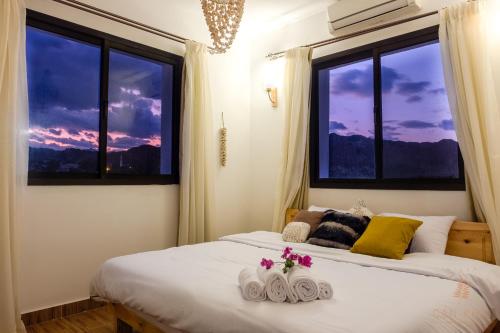 a bedroom with two beds and two windows at Villa Can Kiko in Dahab