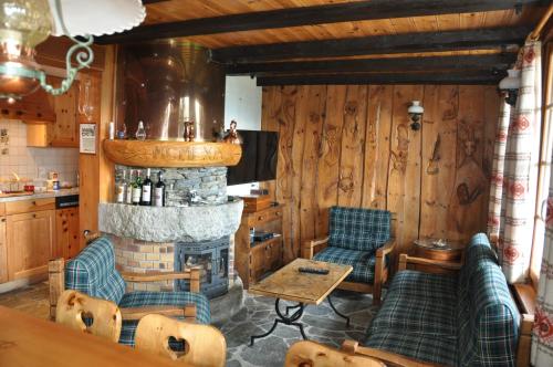 una sala de estar con chimenea y paredes de madera. en Chalet Natacha en Anzère