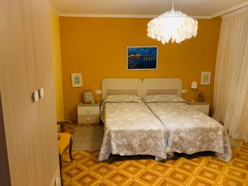 a bedroom with a bed and a chandelier at Casa A Confianza in Isla de Arosa