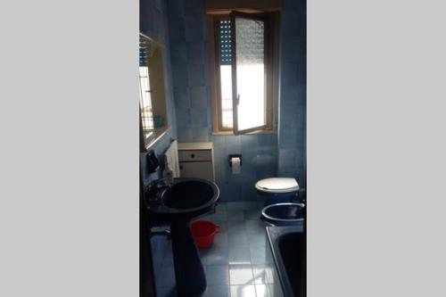 a small bathroom with two toilets and a window at La Sirena Appartamento in Oliveri
