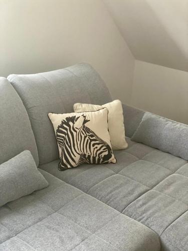 a couch with a zebra pillow on it at Steigerwaldblick Apartments Burgebrach in Burgebrach