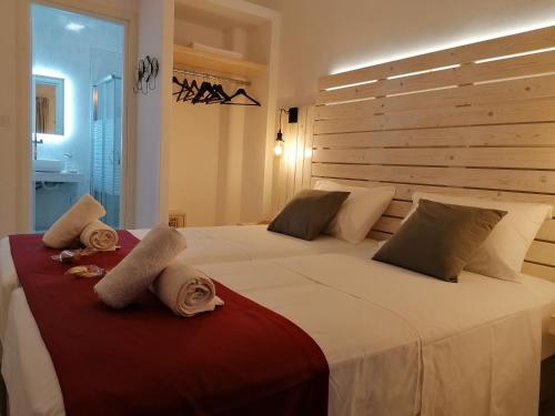 a bedroom with a large bed with towels on it at Afrodite Luxury Rooms in Kalymnos