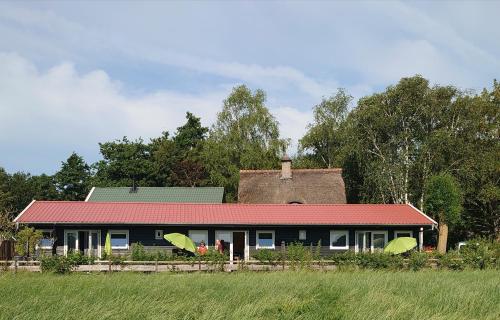 a house with two umbrellas in front of it at B&B ZusenZomer in Oostwoud