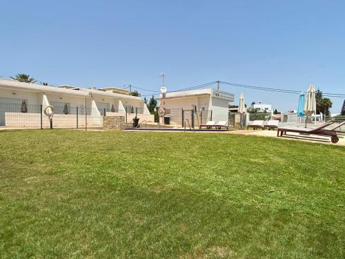 a large grassy field with a building and a park at Mda Playa del Cantal in Mojácar